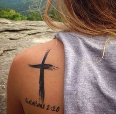 a woman with a cross tattoo on her arm and the words, for i have been crucified with christ and no longer live, but christ lives in me