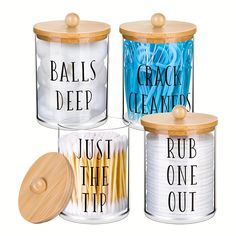 three glass canisters with wooden lids and labels that say balls, deep, rub, and tip