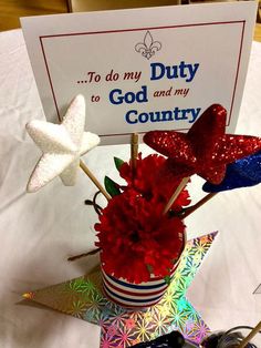 red, white and blue flowers in a pot with a sign on top that says to do my duty to god and my country