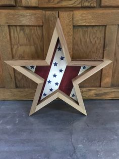 a wooden star with red, white and blue stars painted on the outside of it