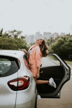 a woman leaning out the back door of a car