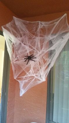 a spider web hanging from the side of a window in a home decorated for halloween