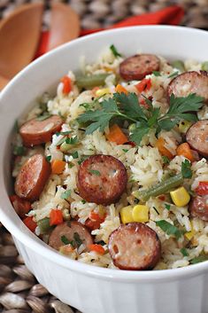 a white bowl filled with rice and sausage