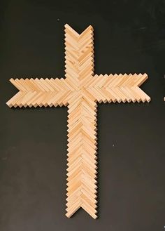 a cross made out of wood sticks on a black surface