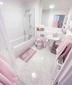 a white bathroom with pink accents and accessories