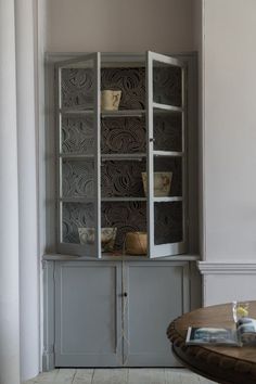 an old china cabinet with baskets on it