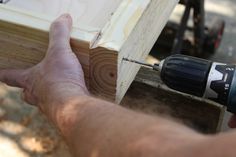 a man is using a drill to attach the top part of a piece of wood