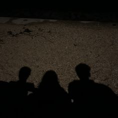 two people sitting on the ground in the dark