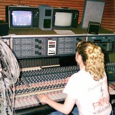 a woman sitting in front of a mixing desk