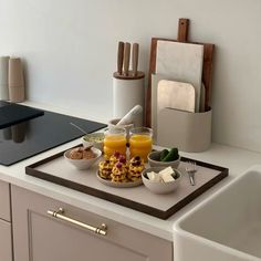 a kitchen counter with breakfast food and utensils on it, including orange juice