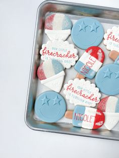 decorated cookies are in a tin on a table