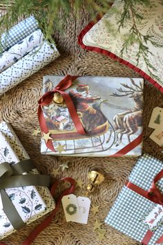 several wrapped presents sitting on top of a wicker floor next to a christmas tree