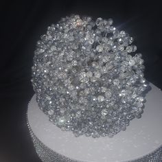 a bunch of glass beads sitting on top of a white stand with diamonds around it