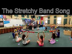 a group of children sitting on the floor with their hands in the air