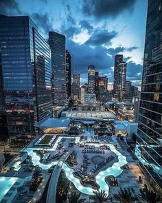 an aerial view of a city at night with skyscrapers in the background and lights on