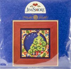 a cross stitch christmas tree in a red frame on a blue background with the words, merry