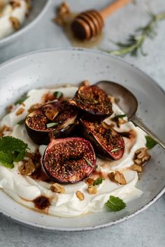 a white plate topped with yogurt and figs