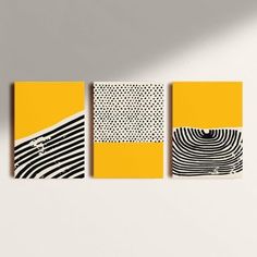 three yellow and black paintings on a white wall