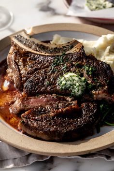 a plate with steak, mashed potatoes and spinach on it is sitting on a table