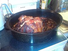 a large pot roasting meat on top of a stove