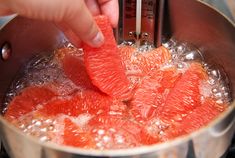 someone is adding grapefruit to the pot with boiling water