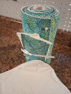 two rolls of toilet paper sitting on top of a counter next to a roll of cloth