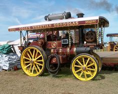 an old fashioned train is parked on the grass