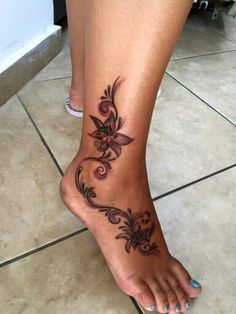 a woman's foot with a flower tattoo on it