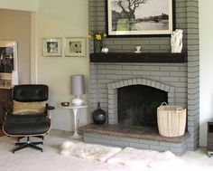 a living room filled with furniture and a fire place in front of a painting on the wall