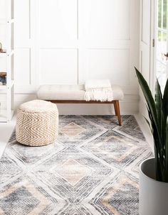 a living room area with a bench, rug and potted plant