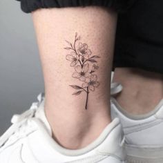 a small flower tattoo on the ankle