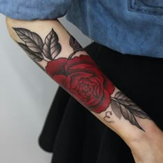 a woman with a red rose tattoo on her arm