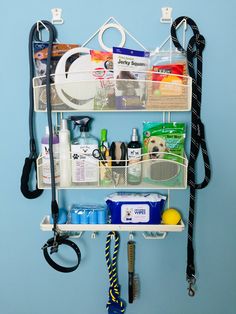 a wall mounted shelf with various items and accessories hanging from it's hooks on the wall