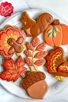 decorated thanksgiving cookies on a plate with autumn leaves and turkeys in the background,