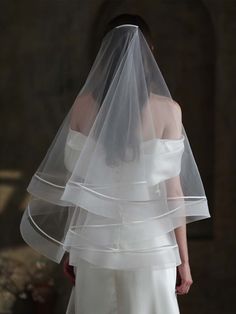 a woman in a wedding dress with a veil on her head