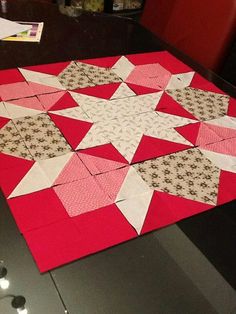 a red and white quilt sitting on top of a table