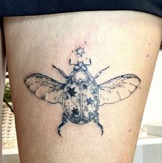 a small insect tattoo on the thigh