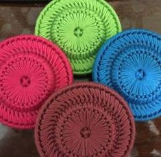 four circular coasters in different colors on a table