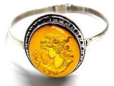 This is beautiful Baltic Sea Genuine Amber Cameo Bracelet hand set in 925 sterling silver. It is very unusual design one of a kind. The amber stone is shallowly carved on the back. When you look at it from the front, the amber stone has magnifying glass effect and you can see 3-D image of a beautiful lady profile with flowers. Fits about 8'' wrist. Stone size is 1.5 x 1.2 x 0.5D''. Weight of this solid bracelet is 31.4 G. Amber is the fossilized, hardened resin of trees, ranging in age from less than a million to more than 300 million years old. This beautiful Baltic Amber has been popular throughout the World for Centuries and is reflected in many of the regions folk tales. Amber Jewels are actually pieces of petrified tree sap and found in only three areas throughout the World. Occasiona Cameo Bracelet, Tree Sap, Glass Effect, Cognac Color, European Design, Amber Stone, Folk Tales, Baltic Sea, Unusual Design