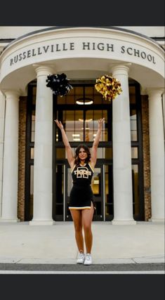 a cheerleader stands in front of the russellsville high school building with her pom poms