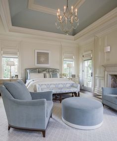 a bedroom with a bed, chair and ottoman in it's centerpieces