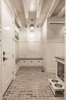 an image of a kitchen with white cabinets and tile flooring on the bottom level