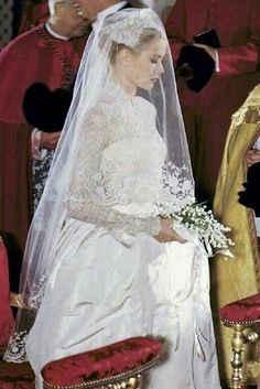 a woman in a wedding dress standing next to a man