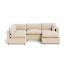 a beige sectional couch sitting on top of a white floor