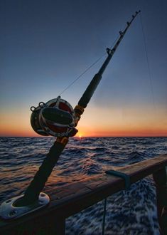 a fishing rod on the deck of a boat at sunset