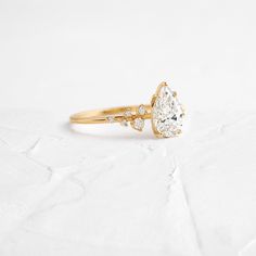 a yellow gold engagement ring with a pear shaped diamond