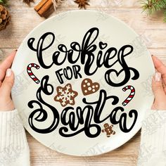 two hands holding a plate with cookies for santa on it and the words cookies for santa written