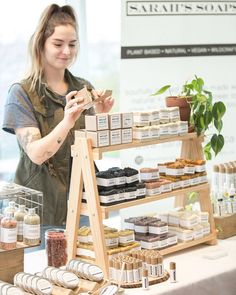 a woman standing in front of a table filled with lots of food and condiments