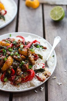 a white plate topped with rice covered in meat and veggies on top of it