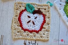 two crocheted apples are sitting on a table